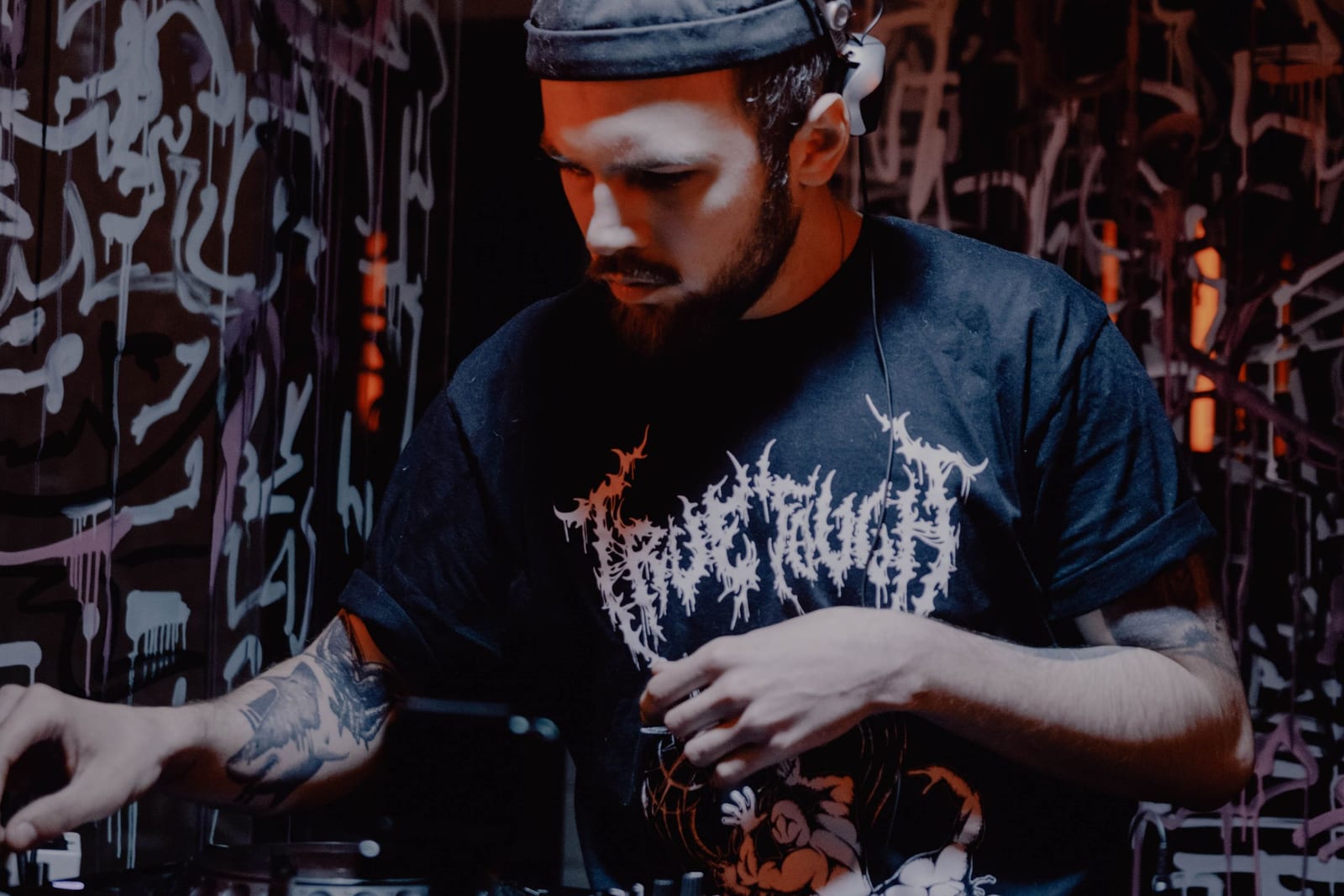 DJ bak deckene foran en graffitivegg